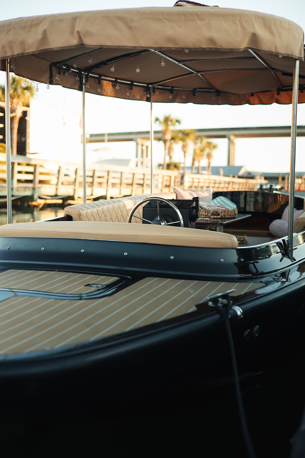 The Joyride boat's teak bow and canopy with string lights at Savannah Bend Marina