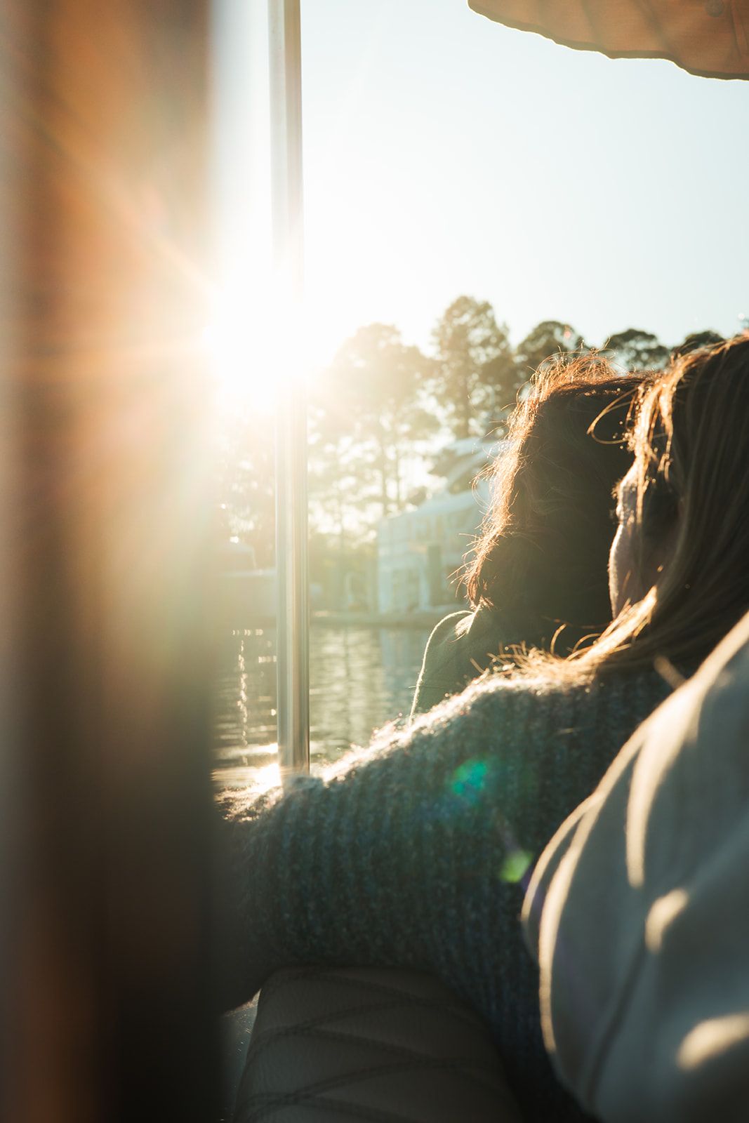 Guests backlit by late-afternoon sun on the water