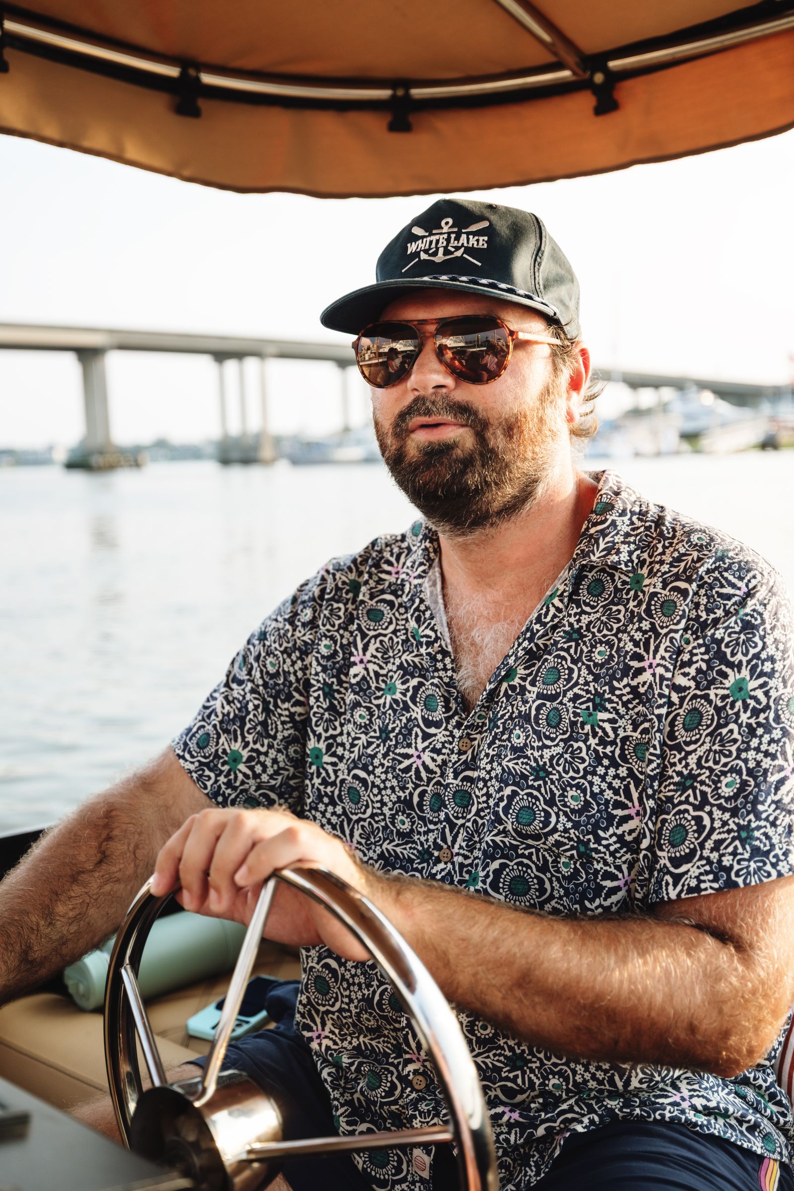 Captain Malcolm at the wheel with the bridge and marina behind